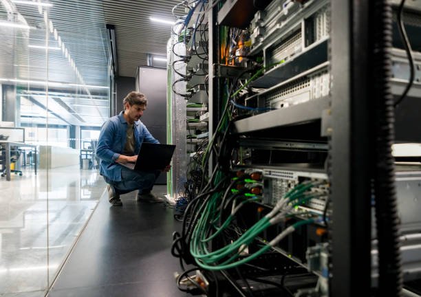 Latin American computer technician fixing a network server the office – focus on foreground
