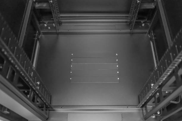 Showing the detail of the 19-inch mounting posts together with cable entry plates seen on the base of the cabinet. Seen in a data centre, the cabinet will be housing Internet routers and servers.