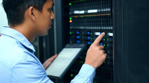 System administrator working with tablet in data center.