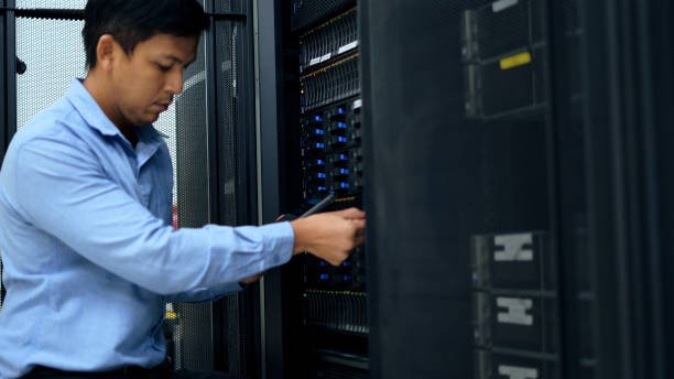 System administrator working with tablet in data center.