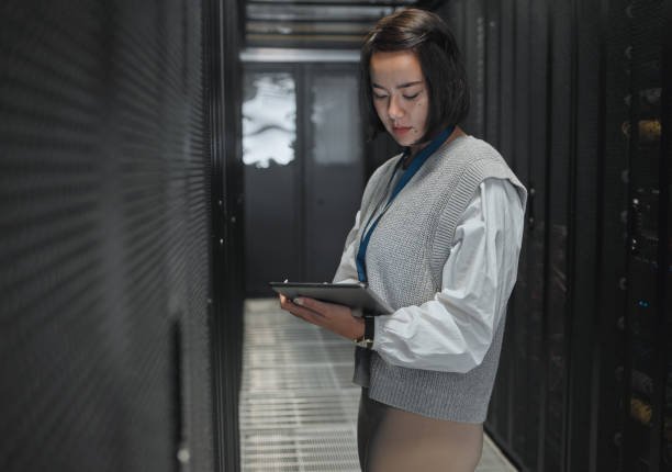 Tablet, server room and dashboard with a programmer asian woman at work on a computer mainframe. Software, database and information technology with a female coder working alone on a cyber network